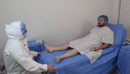 Doctor Jess wears hazmat medical surgical PPE and collects specimen samples from Nick