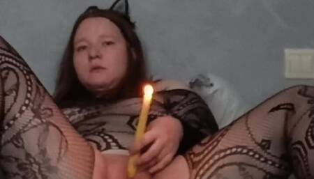 Passionate kitty in a mesh suit masturbates and inserts a burning candle into herself