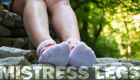 Mistress teases feet in white socks outdoors in the forest