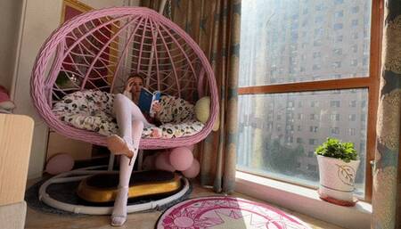girl in white tights and expensive high-heeled sandals enthusiastically reads a book and plays with shoes