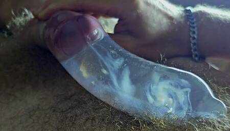 The guy cums in a condom with hot water with powerful volleys