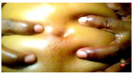 Ebony Goddess massages oil into belly
