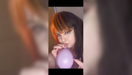 Goth girl blows up balloons