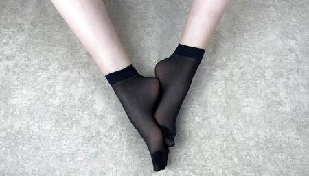 Gloria Gimson in black nylon socks massages her feet