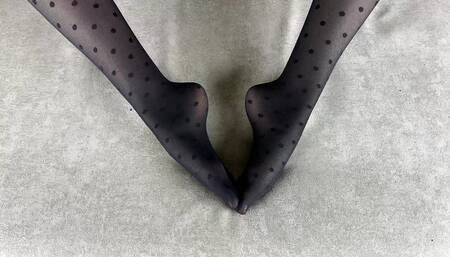 Girl in black nylon tights caresses her legs in different poses