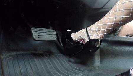 Shiny black stripper heels and fishnets pounding the pedal