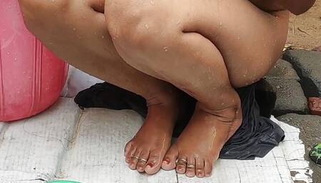 Indian house wife bathing outside with