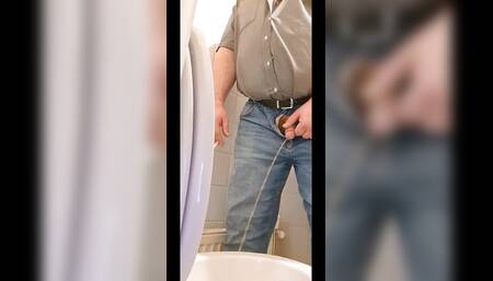 Fat smoking man pisses into toilet