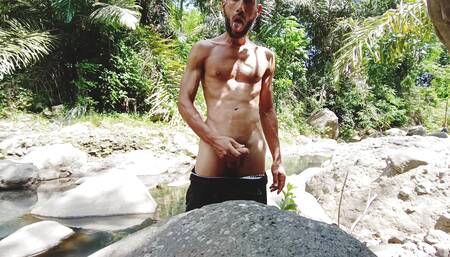 Masturbation by a tropical river and huge and thick cumshot on a stone