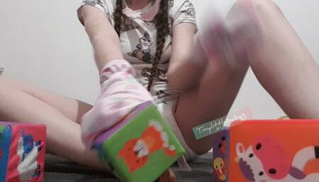 Baby in mittens playing with blocks