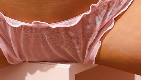 Beauty in pink panties humps pussy against the table corner.