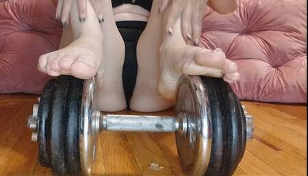Feet Playing with 60 LB Dumbbell