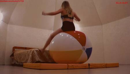 Alla does gymnastics with a large beach ball and has fun jumping on it and pumping it up with her mouth