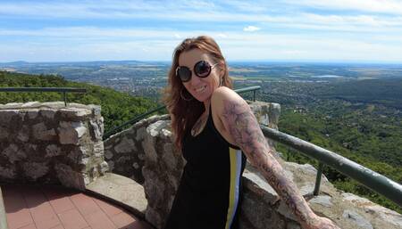 Tattooed Mom is hiking in the woods. She enjoys summer and outdoor nudity
