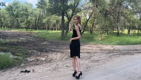 A girl in very high-heeled shoes walks through very deep mud puddles, leaving holes in the mud from her heels (re-realize)