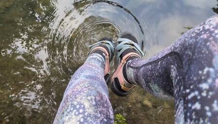 Fifi playing in the creek after yoga in leggings and socks with sandals