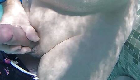 Gay guy cheekily jerks off his fat cock in a public thermal pool. Hot underwater fun.
