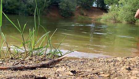 Trans-girl swimming in jeans and pink top in the lake..
