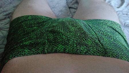 Guy in green swimming trunks massages his dick
