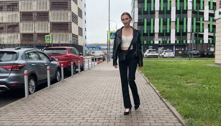 A girl in elegant high-heeled shoes walks along a broken road and her shoes slip into a muddy puddle, then the road only gets worse and her heels get very dirty