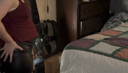 Woman in Leather Skirt and Boots Struggles to Lift Bed