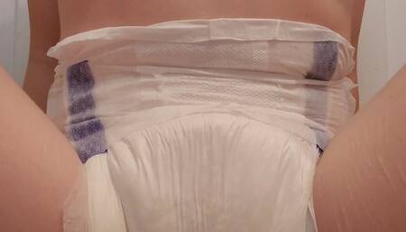 Pinkie wets her diaper while sitting on a mat