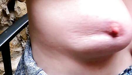 Slapping her naked breasts on public stairs