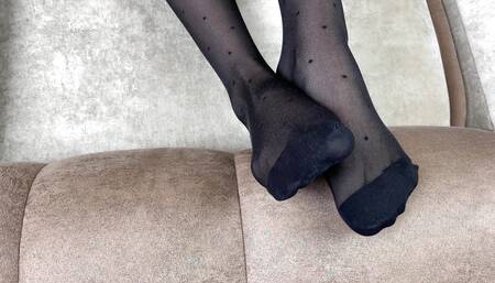 Foot mistress loves to rub her feet in black nylon stockings
