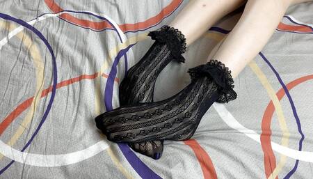 Caressing long legs of girl in black lace socks