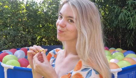 Nailpopping 50 balloons in a swimmingpool