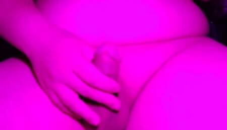 Asian boy completes a perfect orgasm in a pink-lit room