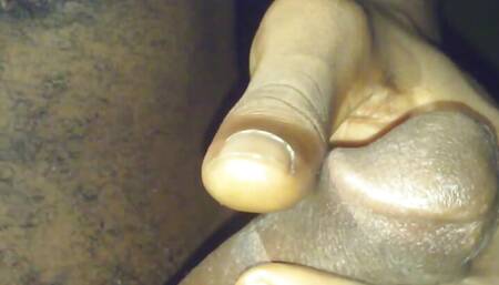 Sitting down in a chair relaxed and playing with the big black dick