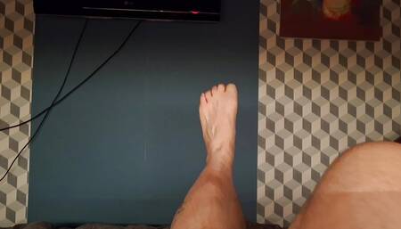 A fat man plays with his feet, naked in bed