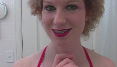 Topless woman with permed hair showing off braces