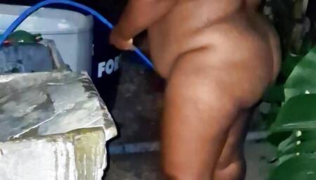 Evangelical stepmother from the favela takes a hose bath in the alley, outdoors