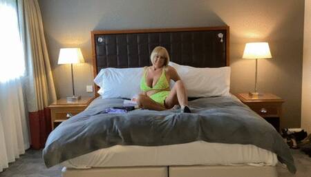 Bags on a hotel bed, in neon bra and panties