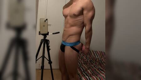 Young fit guy flexing in a jockstrap