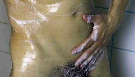 sexy guy washes his muscular hot body with foam in the shower after a workout