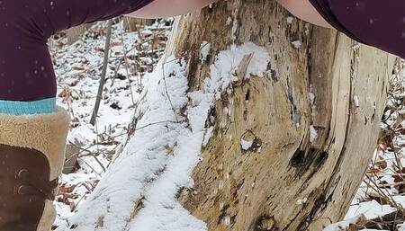 Peeing up against a tree in winter