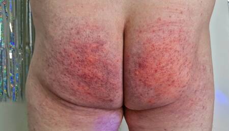 Dominatrix Nika punishes slave by spanking his bare ass until it turns red. Femdom BDSM spanking