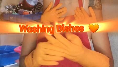 Washing dishes with orange gloves